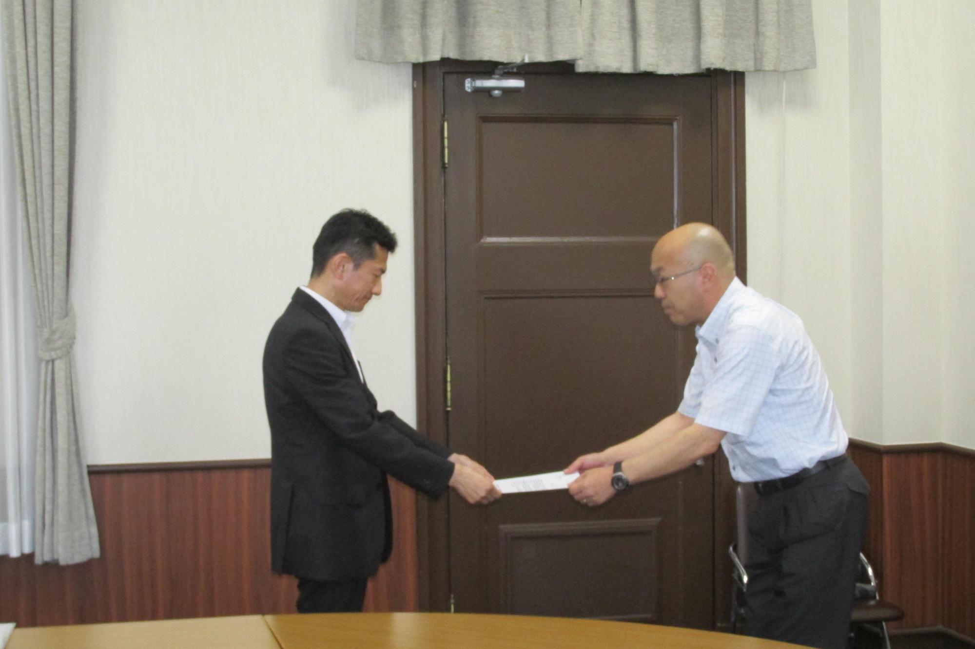 本田泉南市上下水道部長が、植田大阪府副知事に要望書を手渡している写真