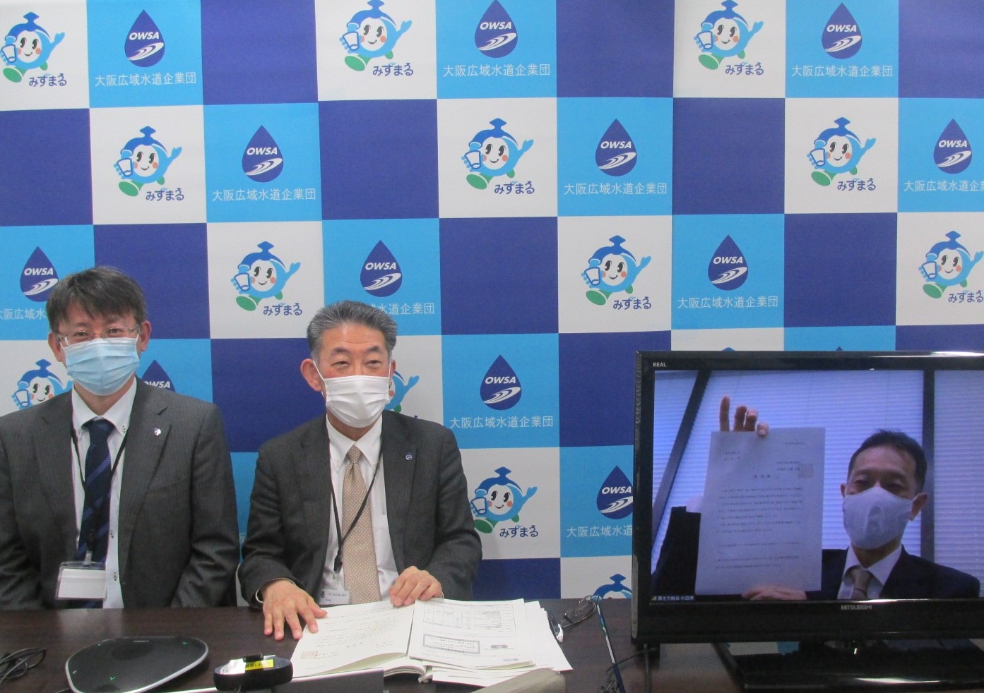 吉田副企業長と中田部長が、熊谷課長に要望書を渡している写真