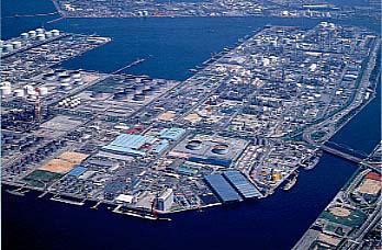 海に囲まれ、大小様々な建物が密集した広い工業地域を上空から撮影した航空写真
