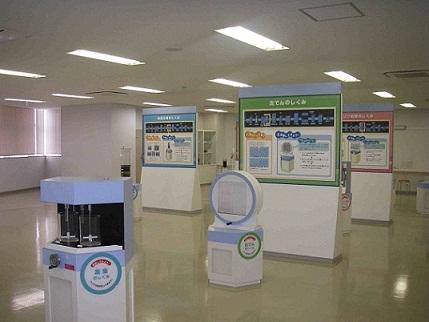 展示施設内における模擬実験装置群の展示風景の写真。装置と共に各々のしくみを解説したパネルも併設されている