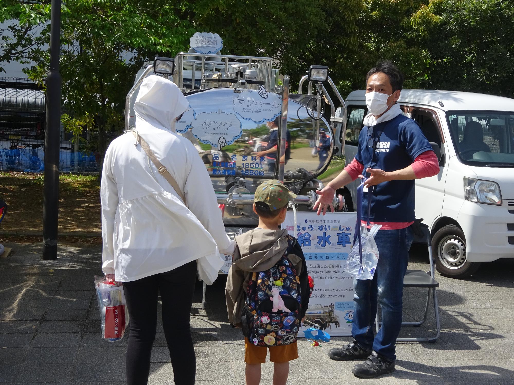 給水車前で展示説明する様子