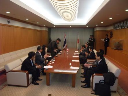 タイと日本の国旗が飾られた会議室でスーツ姿の役員たちが着席している写真